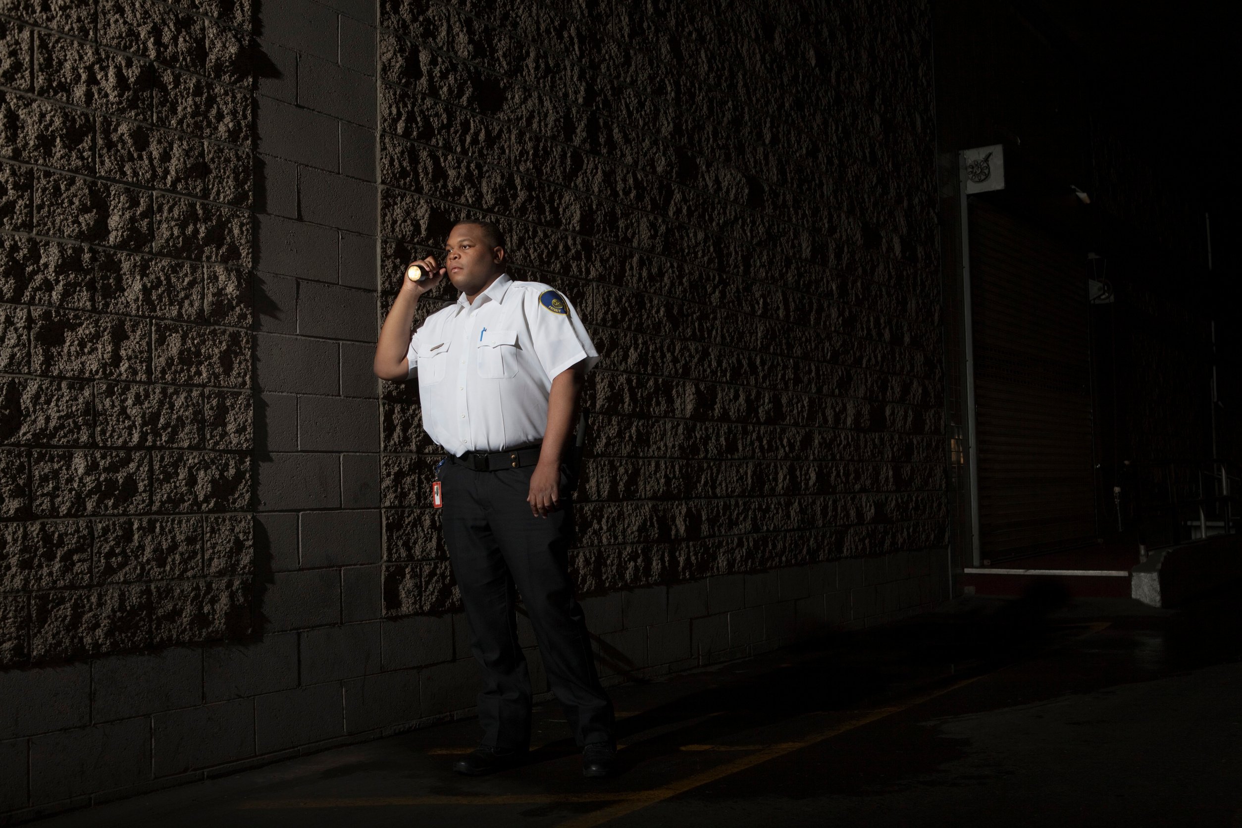 Security guard patrols at night with torch